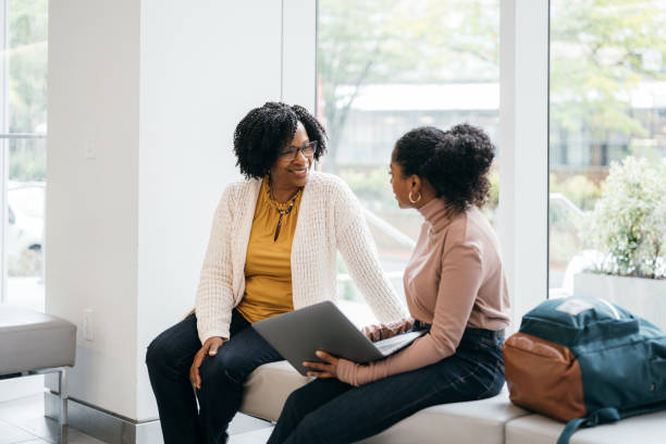 Teacher talking to University Student in faculty lobby
